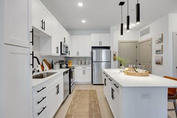 A kitchen with white cabinets and a counter top